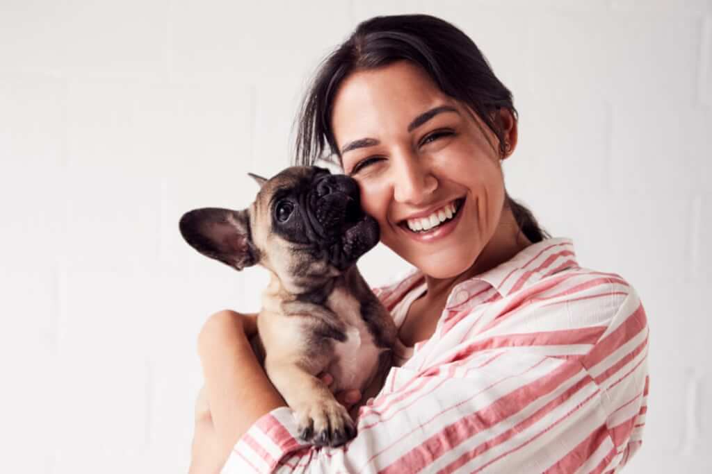 woman holding french bulldog puppy