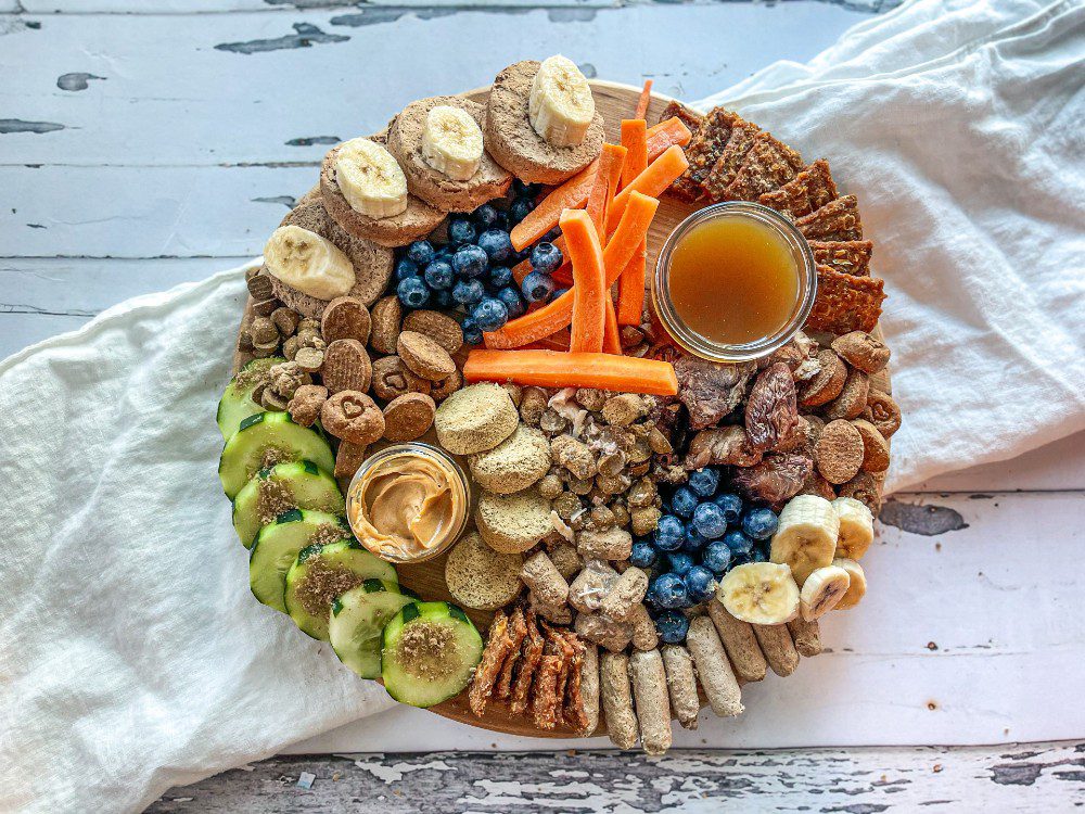Barkuterie board with dog treats and fruits and vegetables