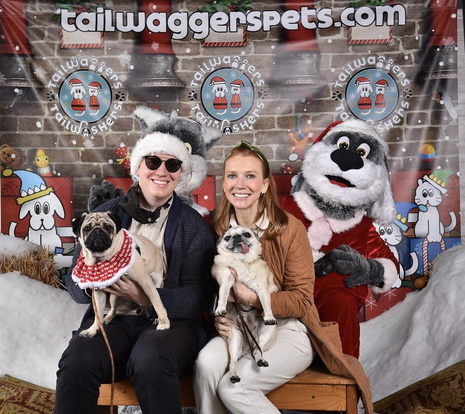 Man & woman with two pugs at a holiday party